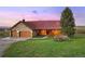 Inviting stone and log cabin with a red roof, two-car garage, and a charming wagon accent at 5351 Tall Horse Trl, Sedalia, CO 80135