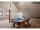 A game room with a billiard table under an angled ceiling with a skylight and space for entertaining and leisure activities at 5351 Tall Horse Trl, Sedalia, CO 80135