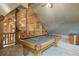 Bright game room with a billiard table, cozy carpet and unique log cabin architecture with a beautiful ceiling fan for ventilation at 5351 Tall Horse Trl, Sedalia, CO 80135
