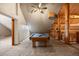 Bright game room with a billiard table, cozy carpet and unique log cabin architecture with a beautiful ceiling fan for ventilation at 5351 Tall Horse Trl, Sedalia, CO 80135