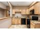 Well-equipped kitchen featuring light wood cabinetry and granite countertops with modern appliances at 5351 Tall Horse Trl, Sedalia, CO 80135