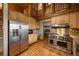 Log-home kitchen with stainless steel appliances, wood cabinets, and walk-in pantry at 5351 Tall Horse Trl, Sedalia, CO 80135