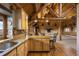 Open kitchen with wood cabinets, countertops, an island, and views of the living space and fireplace at 5351 Tall Horse Trl, Sedalia, CO 80135
