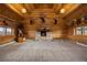 Spacious living room with stone fireplace and vaulted log beam ceilings at 5351 Tall Horse Trl, Sedalia, CO 80135