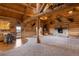 Open floor plan living room with log beam ceilings, a stone fireplace, and decor at 5351 Tall Horse Trl, Sedalia, CO 80135