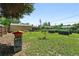 Spacious backyard featuring a well-maintained lawn, established garden beds, and a charming beehive at 1240 Ulster St, Denver, CO 80220