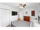 Bedroom features a ceiling fan, closet, and dresser with light-filled windows at 1240 Ulster St, Denver, CO 80220