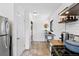Galley kitchen featuring tiled flooring, stainless steel appliances, and access to in-unit laundry at 1240 Ulster St, Denver, CO 80220