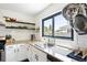 Modern kitchen with granite counters, stainless steel sink, and white subway tile backsplash at 1240 Ulster St, Denver, CO 80220