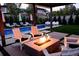 Inviting pool area with a modern fire pit, white Adirondack chairs, and lush landscaping at 35 S Forest St, Denver, CO 80246