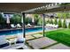 Backyard pool with a pergola, lounge chairs, green lawn, and manicured landscaping at 35 S Forest St, Denver, CO 80246