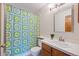 Cozy bathroom featuring a vanity with a sink, toilet, and colorful patterned shower curtain at 3311 E Euclid Ave, Centennial, CO 80121