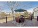 Outdoor deck features a grill, dining set, umbrella, and views of the backyard and surrounding landscape at 3311 E Euclid Ave, Centennial, CO 80121