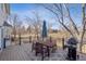 Outdoor deck features a grill, dining set, umbrella, and views of the backyard and surrounding landscape at 3311 E Euclid Ave, Centennial, CO 80121