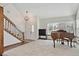 Bright and airy living room featuring plush carpeting, a decorative staircase, and a large picture window at 3311 E Euclid Ave, Centennial, CO 80121