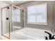Modern bathroom features a soaking tub with tile surround, and glass enclosed shower with tiled walls at 25046 E Bayaud Pl, Aurora, CO 80018