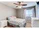 This cozy bedroom has a ceiling fan, a window with pretty curtains and white nightstands at 25046 E Bayaud Pl, Aurora, CO 80018