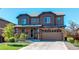 Inviting two-story home featuring a two-car garage, manicured lawn, and stylish stone and siding accents at 25046 E Bayaud Pl, Aurora, CO 80018