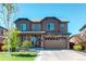 Beautiful two-story home with a stone and brick exterior, a two car garage and a well-manicured lawn at 25046 E Bayaud Pl, Aurora, CO 80018