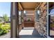 Covered front porch with stone accents and wood pillars providing a cozy outdoor space with view to the neighborhood at 25046 E Bayaud Pl, Aurora, CO 80018