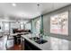 Bright and open kitchen with a central island, stainless steel sink, and view to the living area at 25046 E Bayaud Pl, Aurora, CO 80018