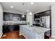 Modern kitchen featuring stainless steel appliances, dark cabinets, granite countertops and center island with sink at 25046 E Bayaud Pl, Aurora, CO 80018