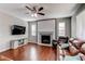 Bright living room featuring hardwood floors, a fireplace, and a modern entertainment center at 25046 E Bayaud Pl, Aurora, CO 80018