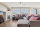 Gathering room featuring stone fireplace, hardwood floors, and large windows at 1705 Peridot Ct, Castle Rock, CO 80108