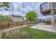 The fenced backyard with mature trees and garden features a concrete patio and ample space for outdoor activities at 12682 Fairfax St, Thornton, CO 80241