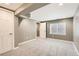 Finished basement with neutral walls, carpet, and a large window providing natural light at 12682 Fairfax St, Thornton, CO 80241