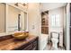 An updated bathroom featuring a vessel sink, decorative tile, and modern fixtures create a spa-like retreat at 12682 Fairfax St, Thornton, CO 80241