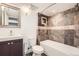 Bathroom featuring custom tilework, a soaking tub, and a vanity with modern fixtures at 12682 Fairfax St, Thornton, CO 80241