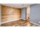 Bedroom featuring a wood accent wall and stylish bamboo flooring, creating a warm and inviting space at 12682 Fairfax St, Thornton, CO 80241