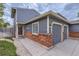 Inviting entrance featuring brick accents, a well-lit walkway, and attached two-car garage at 12682 Fairfax St, Thornton, CO 80241