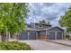 Beautifully kept home featuring a three-car garage, brick accents, and mature landscaping at 12682 Fairfax St, Thornton, CO 80241