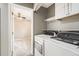 Laundry room featuring a washer and dryer with a view to another carpeted room at 12682 Fairfax St, Thornton, CO 80241