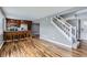 Spacious living room with hardwood floors connects to the kitchen with staircase to the upper level at 12682 Fairfax St, Thornton, CO 80241