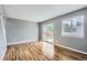 Bright living room featuring hardwood floors, neutral walls, and sliding glass doors leading to the backyard at 12682 Fairfax St, Thornton, CO 80241