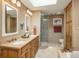 Elegant bathroom featuring double sinks, a glass-enclosed shower, and built-in cabinetry at 947 Dogwood Dr, Golden, CO 80401