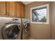 Convenient laundry room with modern washer and dryer units and ample cabinet space at 947 Dogwood Dr, Golden, CO 80401