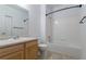 Bathroom with wooden cabinets, white counter, toilet, mirror, and shower/tub combo at 4451 S Ammons St # 2-204, Littleton, CO 80123