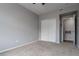 A carpeted bedroom featuring a closet with sliding doors and a doorway leading to a bathroom at 4451 S Ammons St # 2-204, Littleton, CO 80123