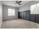 Spacious carpeted bedroom features a modern ceiling fan, wainscotting, and natural light through large windows at 4451 S Ammons St # 2-204, Littleton, CO 80123