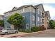 Apartment building with blue siding, well-maintained landscaping, and parking area at 4451 S Ammons St # 2-204, Littleton, CO 80123