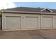 Three-car garage for tenants with light gray siding, and asphalt driveway at 4451 S Ammons St # 2-204, Littleton, CO 80123