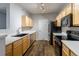 Kitchen area with light wood cabinets, stainless steel appliances, and hardwood floors at 4451 S Ammons St # 2-204, Littleton, CO 80123