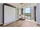 Bright bedroom featuring a Murphy bed, built-in shelves, and a large window with city views at 3100 E Cherry Creek South Dr # 1101, Denver, CO 80209
