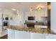 Stylish kitchen with granite countertop bar, stainless appliances, and modern light fixtures at 3100 E Cherry Creek South Dr # 1101, Denver, CO 80209