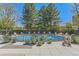 Inviting pool area with lounge chairs, decorative planters, enclosed by black metal fencing and mature trees at 3100 E Cherry Creek South Dr # 1101, Denver, CO 80209