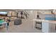 Open basement area with multiple seating areas, a bookshelf, exercise equipment, and stairs at 2200 Cadman St, Berthoud, CO 80513